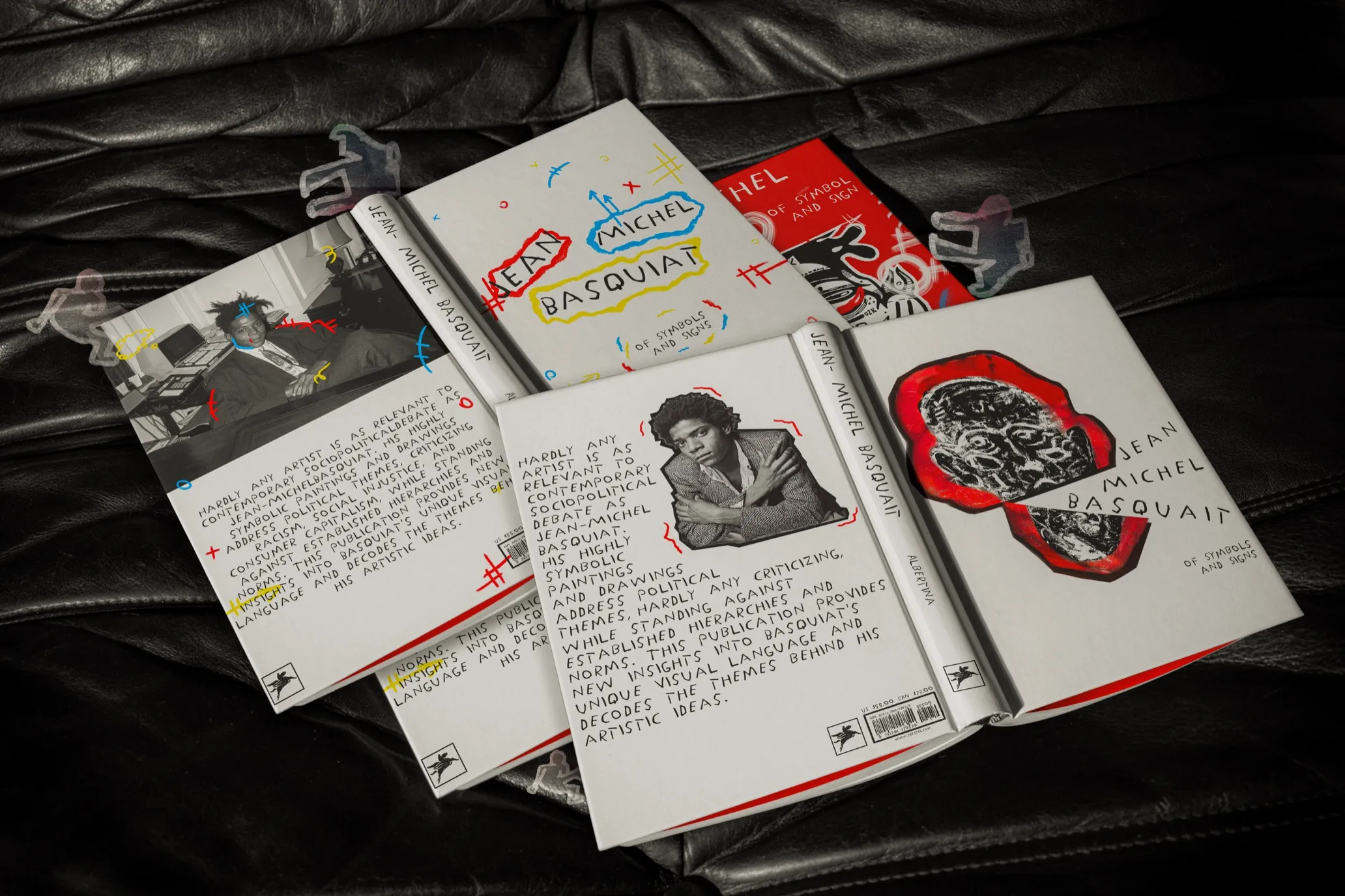 Jean-Michel Basquiat book covers laid out on a leather couch